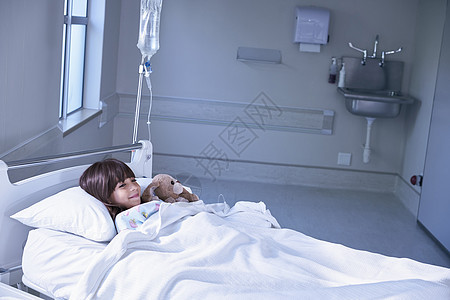 在医院儿童病房抱着玩具兔子的床上女病人图片