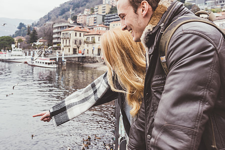 意大利科莫湖一对快乐的年轻夫妇手指湖边图片