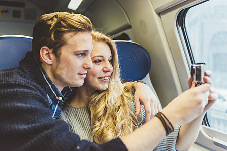 通过火车厢窗口拍摄的年轻夫妇图片
