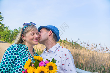 情侣拿着鲜花亲吻脸颊图片