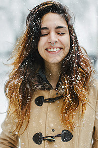 女人在雪中穿大衣眼睛闭上微笑图片