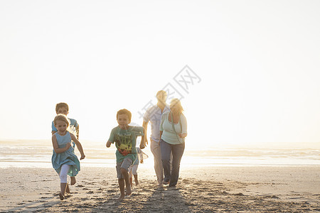 在海滩上奔跑的家庭前视线图片