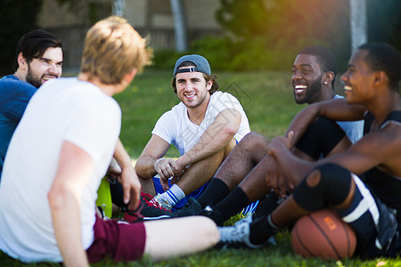 一群男朋友坐在一起公园里笑着图片