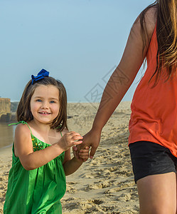 美国新泽西州阿斯伯里公园海滩上抱着少女姐妹手的可爱孩图片