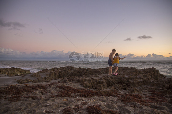 在海边岩石上玩耍的小孩儿图片