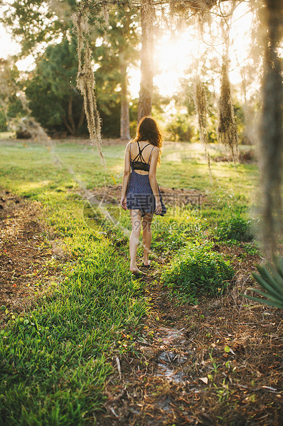 公园里漫步的年轻女性背影图片