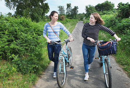 沿车道推自行车的年轻女性图片