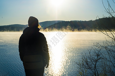日落时在湖边观光的旅游者图片