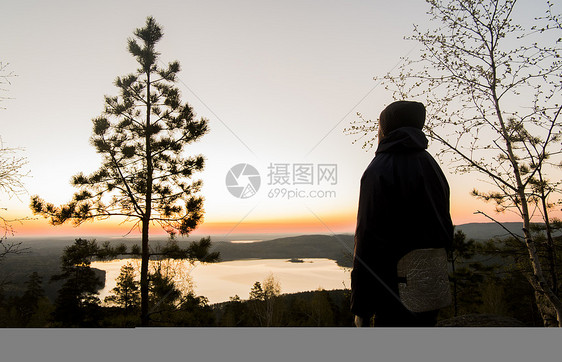 享受日落时湖景观的旅游者图片