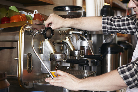 面包店男工人使用咖啡机制作咖啡图片