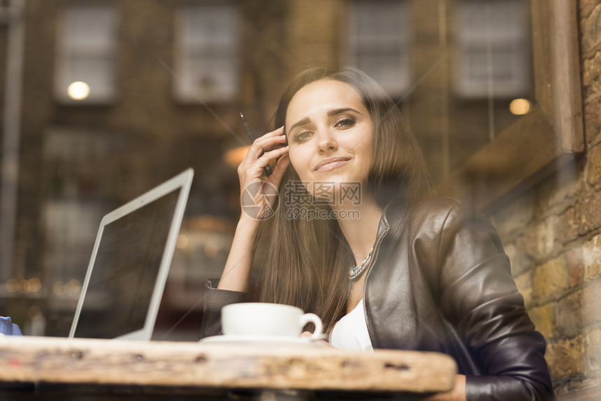在咖啡馆用笔记本电脑的年轻女商人图片