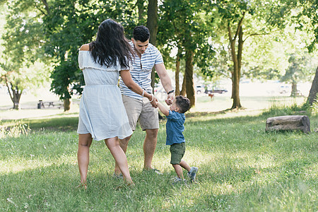 父母在美国纽约布朗克斯PelhamBay公园与幼儿子握手图片