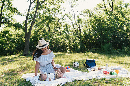 美国纽约布朗克斯PelhamBay公园野餐毯上的中成年妇女和小儿子图片