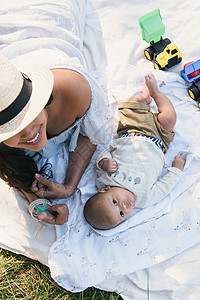 美国纽约布朗克斯PelhamBay公园的婴儿和母亲从野餐毯上向看图片
