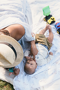 美国纽约布朗克斯PelhamBay公园野餐毯上躺着的男婴和母亲视线图片
