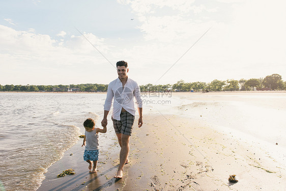 美国纽约布朗克斯PelhamBay公园海滩上与幼儿子一起散步的年轻人图片