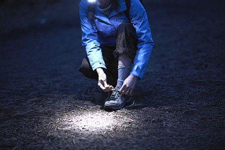 夜间穿戴头领鞋带的女徒步者图片