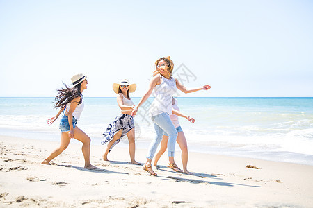 四位成年女朋友在美国加利福尼亚州马里布海滩上玩耍图片