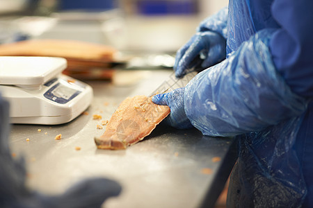 工厂里切割鱼肉的工人图片