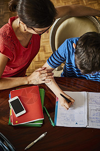 帮助儿子完成家庭作业的母亲图片