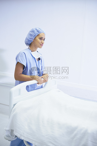 女护士在医院床位旁站立图片