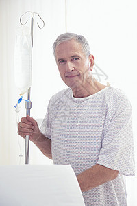 医院内静脉滴液的老年男患者肖像图片