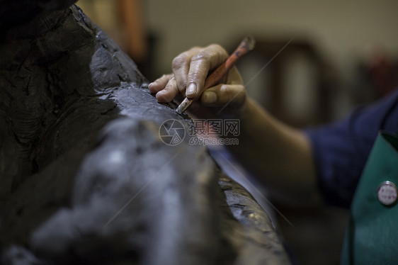 艺术家工作室雕塑家拿着工具制作雕塑的手图片