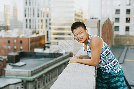 靠在矮墙上的青年男子图片