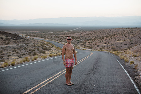 站在美国内华达州消防谷公园的农村路上赤裸上身的男子图片
