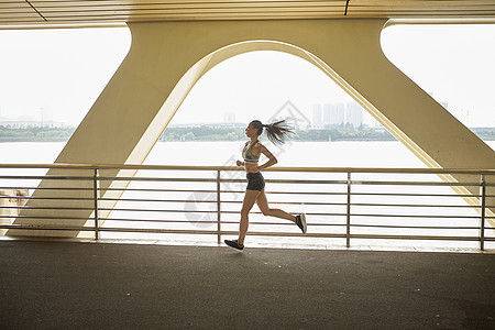 运动女性在桥上跑步图片