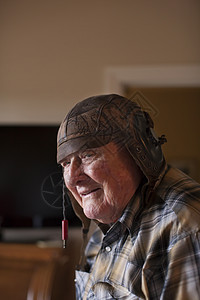 室内老人戴旧式皮革足球头盔图片