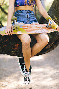 坐在树上的女人拿着滑板图片