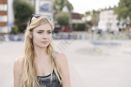 年轻女滑板选手的肖像长金发滑板场图片