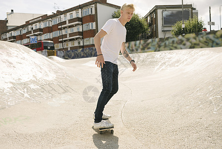 在滑板场玩的年轻男运动员图片