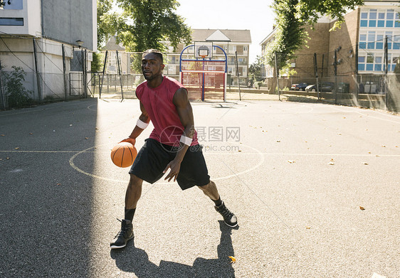 在篮球场打篮球的青年男子图片