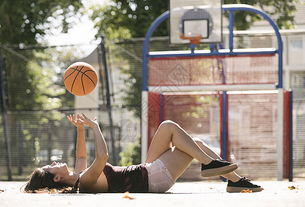 年轻女子躺在篮球场上图片