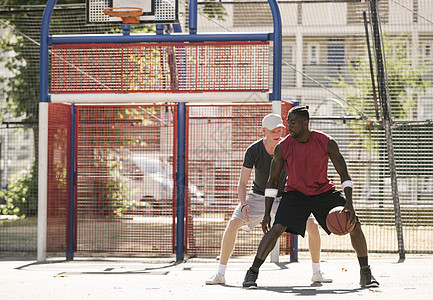 两名男篮球运动员在篮球场上练习图片