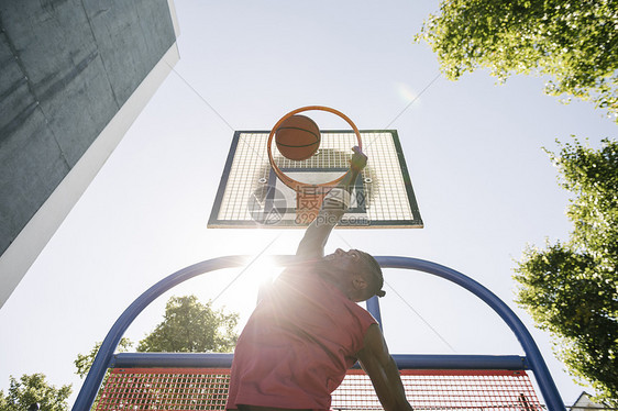 年轻男篮球运动员在日光篮球赛中投篮图片