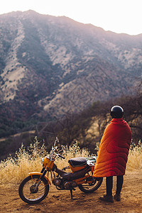 站在摩托车旁边的男子裹着毯看观景后视塞科亚公园美加利福尼亚州图片