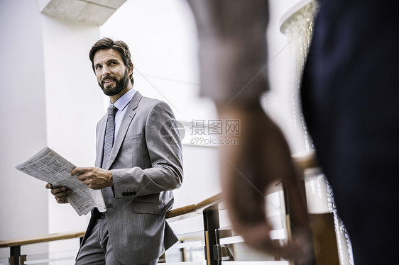 商人在办公室阳台阅读报纸图片