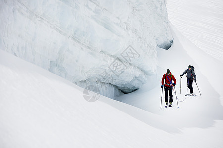 运动员在雪覆盖的山上滑雪图片