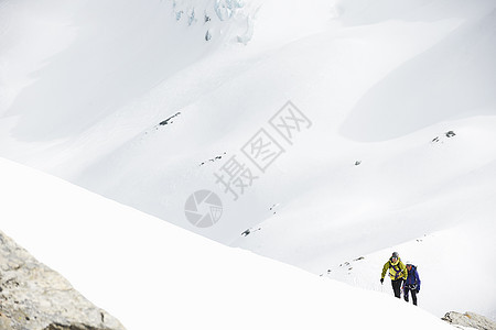 运动员在雪覆盖的山上滑雪图片