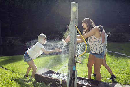 三个成年女朋友玩打斗在花园里喷水管图片