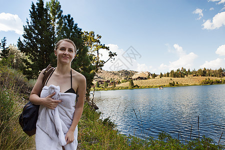 美国加利福尼亚州Mammoth湖边用毛巾包着的年轻女子肖像图片