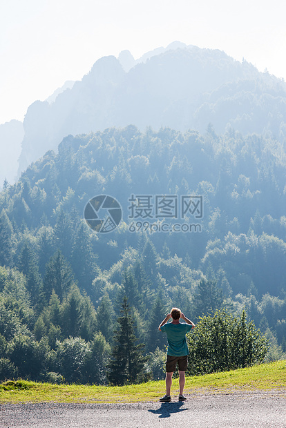 意大利帕索马尼瓦一名男子仰望树木覆盖的群山图片