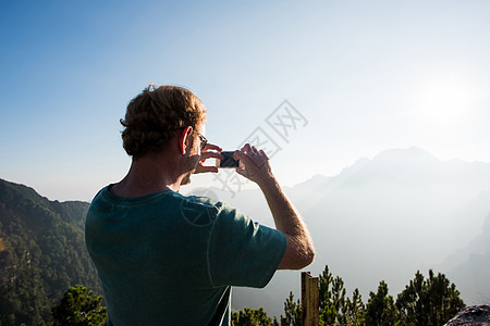 意大利马尼瓦帕索山的男人用手机在拍摄山脉风景图片