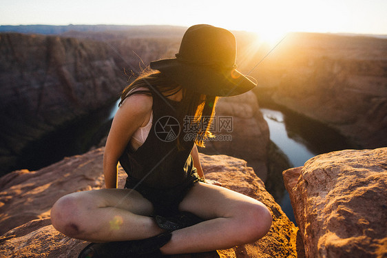 美国亚利桑那州马蹄本德坐在山顶上休息的女性图片