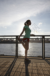 纽约日落大道美国纽约曼哈顿码头妇女伸展腿的侧面视图背景