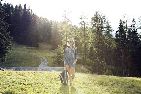 奥地利蒂罗尔州日光下田中步行成年妇女图片