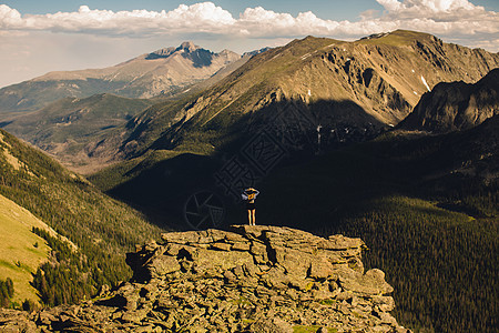 美国科罗拉多州落基山公园一名妇女站在岩石露头上眺望远方图片